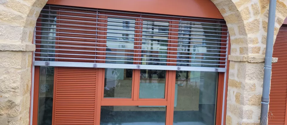 Brise-soleil orange devant une baie cintrée à Buxy