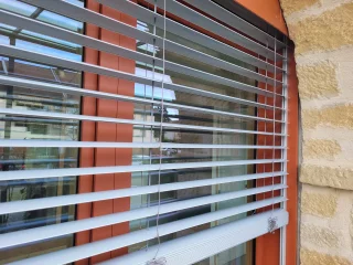 Lames orientées d’un brise-soleil devant une baie vitrée à Buxy