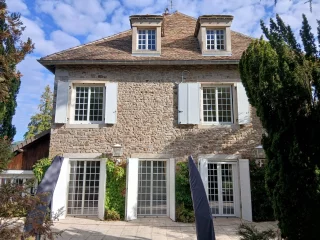 Fenêtres aluminium blanches sur une maison en pierre à Barizey