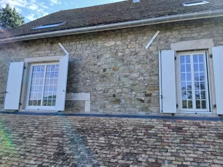 Fenêtres blanches à petits bois dans une façade en pierre à Barizey