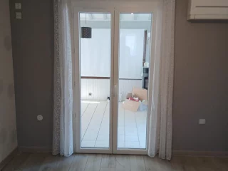 Porte-fenêtre PVC blanche à deux vantaux vue de l’intérieur à Saint-Marcel