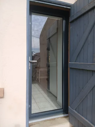 Face extérieure sombre d’une porte d’entrée aluminium vitrée à Givry