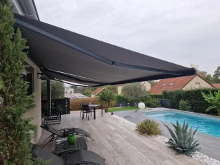 Store banne gris déployé au-dessus d’une terrasse près d’une piscine à La Charmée