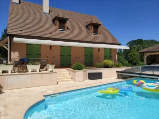 Terrasse et piscine ombragées par un store banne monobloc à Corpeau