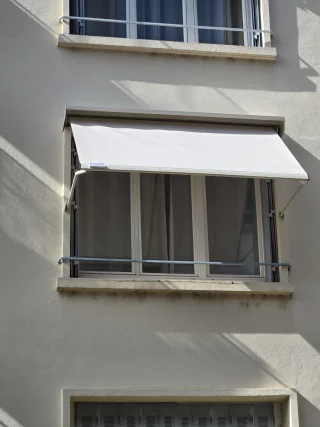 Bannette à projection déployée devant une fenêtre à Chalon-sur-Saône